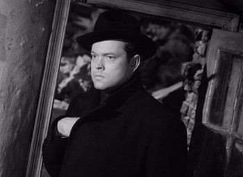 Movie still from “The Third Man” (1949), directed by Carol Reed – A man wearing a black hat and a black coat; Close Up shot, Low angle