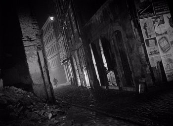 Movie still from “The Third Man” (1949), directed by Carol Reed – A person walking down a street at night; Extreme Wide shot, High angle