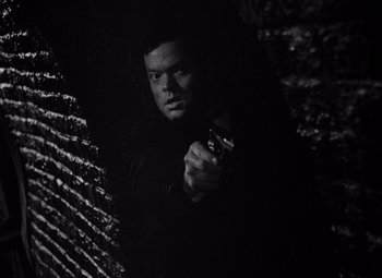 Movie still from “The Third Man” (1949), directed by Carol Reed – A black and white photo of a man holding a gun; Close Up shot, Low angle