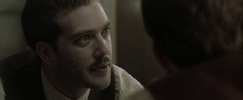 Movie still from “The Thirteenth Floor” (1999), directed by Josef Rusnak – A person looking at a mirror; Close Up shot, Over the shoulder angle