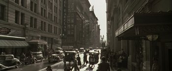 An old photo of a busy city street with cars