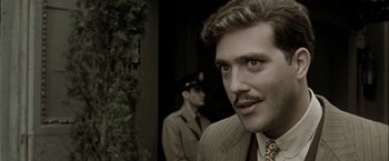 Movie still from “The Thirteenth Floor” (1999), directed by Josef Rusnak – A person wearing a suit and tie; Close Up shot, Over the shoulder angle