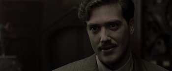 Movie still from “The Thirteenth Floor” (1999), directed by Josef Rusnak – A person wearing a suit and tie; Close Up shot, Low angle