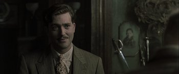 Movie still from “The Thirteenth Floor” (1999), directed by Josef Rusnak – A man wearing a suit and tie standing in front of a mirror; Close Up shot, Over the shoulder angle