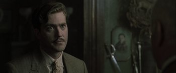 Movie still from “The Thirteenth Floor” (1999), directed by Josef Rusnak – A person wearing a suit and tie; Close Up shot, Over the shoulder angle