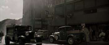 Movie still from “The Thirteenth Floor” (1999), directed by Josef Rusnak – An old truck parked on the side of the street; Extreme Wide shot, High angle