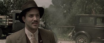 Movie still from “The Thirteenth Floor” (1999), directed by Josef Rusnak – A man wearing a suit and a hat; Close Up shot, Low angle