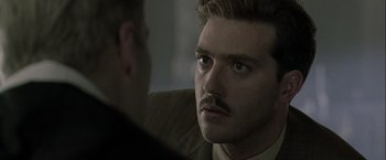 Movie still from “The Thirteenth Floor” (1999), directed by Josef Rusnak – A person with a mustache; Close Up shot, Over the shoulder angle