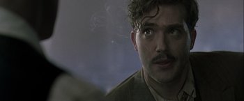 Movie still from “The Thirteenth Floor” (1999), directed by Josef Rusnak – A person with a cigarette in his mouth; Close Up shot, Over the shoulder angle