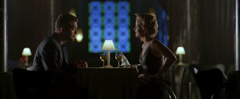 Movie still from “The Thirteenth Floor” (1999), directed by Josef Rusnak – A man and a woman sitting at a table with wine glasses; Medium shot, Low angle