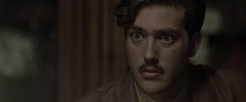 Movie still from “The Thirteenth Floor” (1999), directed by Josef Rusnak – A person with a mustache; Close Up shot, Over the shoulder angle