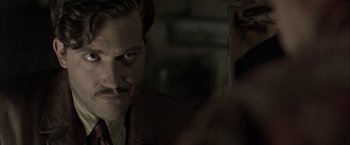 Movie still from “The Thirteenth Floor” (1999), directed by Josef Rusnak – A person wearing a suit and tie; Close Up shot, Over the shoulder angle