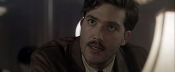 Movie still from “The Thirteenth Floor” (1999), directed by Josef Rusnak – A person wearing a suit and tie; Close Up shot, Over the shoulder angle