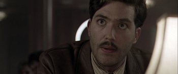 Movie still from “The Thirteenth Floor” (1999), directed by Josef Rusnak – A person wearing a suit and tie; Close Up shot, Low angle