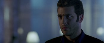 Movie still from “The Thirteenth Floor” (1999), directed by Josef Rusnak – A person wearing a suit and tie; Close Up shot, Over the shoulder angle