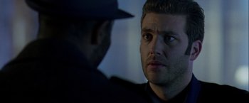 Movie still from “The Thirteenth Floor” (1999), directed by Josef Rusnak – A man in a hat and a black jacket looking at another man in a black jacket; Close Up shot, Over the shoulder angle