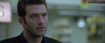 Movie still from “The Thirteenth Floor” (1999), directed by Josef Rusnak – A person wearing a suit and tie; Close Up shot, Over the shoulder angle