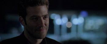 Movie still from “The Thirteenth Floor” (1999), directed by Josef Rusnak – A man's face in front of blurry lights; Close Up shot, Over the shoulder angle