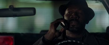 Movie still from “The Thirteenth Floor” (1999), directed by Josef Rusnak – A man talking on a cell phone while sitting in a car; Close Up shot, Low angle