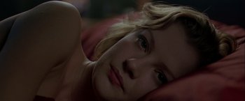 Movie still from “The Thirteenth Floor” (1999), directed by Josef Rusnak – A young woman laying on the ground with her head resting on her hand; Close Up shot, High angle