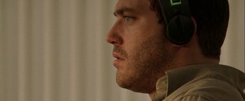 Movie still from “The Thirteenth Floor” (1999), directed by Josef Rusnak – A person wearing headphones; Close Up shot, Low angle