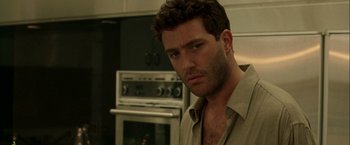 Movie still from “The Thirteenth Floor” (1999), directed by Josef Rusnak – A person standing in a kitchen; Close Up shot, Over the shoulder angle