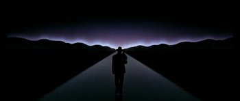 Movie still from “The Three Musketeers” (1993), directed by Stephen Herek – A man standing in front of an image of mountains at night; Extreme Wide shot, Low angle