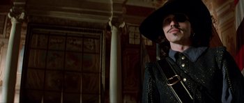 Movie still from “The Three Musketeers” (1993), directed by Stephen Herek – A man wearing a black hat and a black jacket; Medium shot, Low angle