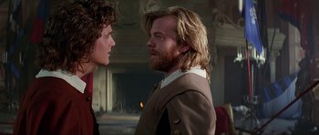 Movie still from “The Three Musketeers” (1993), directed by Stephen Herek – A man standing next to another man in front of a fireplace; Close Up shot, Over the shoulder angle