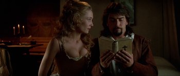 Movie still from “The Three Musketeers” (1993), directed by Stephen Herek – A man and a woman looking at a book; Close Up shot, Low angle