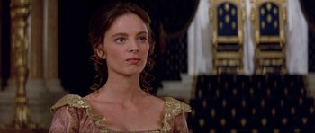 Movie still from “The Three Musketeers” (1993), directed by Stephen Herek – A beautiful young woman wearing a gold dress; Close Up shot, Over the shoulder angle
