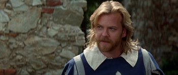 Movie still from “The Three Musketeers” (1993), directed by Stephen Herek – A person with long blonde hair; Close Up shot, Over the shoulder angle
