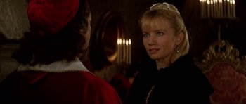 Movie still from “The Three Musketeers” (1993), directed by Stephen Herek – A woman wearing a tiara and a black dress; Close Up shot, Over the shoulder angle