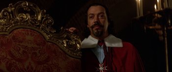 Movie still from “The Three Musketeers” (1993), directed by Stephen Herek – A man with a beard wearing a red and white outfit; Close Up shot, Low angle