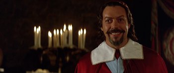 Movie still from “The Three Musketeers” (1993), directed by Stephen Herek – A person with a beard wearing a robe; Close Up shot, Over the shoulder angle