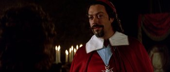 Movie still from “The Three Musketeers” (1993), directed by Stephen Herek – A person wearing a red robe; Close Up shot, Over the shoulder angle