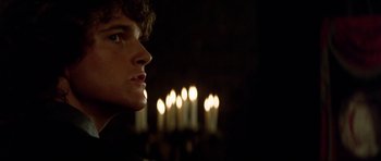 Movie still from “The Three Musketeers” (1993), directed by Stephen Herek – A young man looking into the distance in front of candles; Close Up shot, Low angle