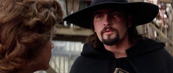 Movie still from “The Three Musketeers” (1993), directed by Stephen Herek – A man with a beard wearing a black hat; Close Up shot, Low angle