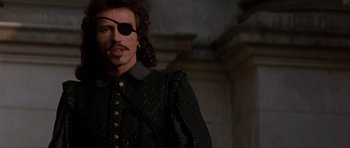 Movie still from “The Three Musketeers” (1993), directed by Stephen Herek – A person wearing a pirate eye patch; Close Up shot, Over the shoulder angle