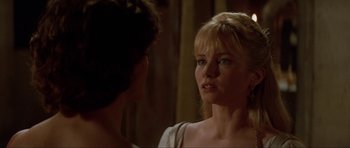 Movie still from “The Three Musketeers” (1993), directed by Stephen Herek – A woman with blonde hair and a white shirt is talking to another woman; Close Up shot, Over the shoulder angle