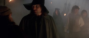 Movie still from “The Three Musketeers” (1993), directed by Stephen Herek – A man in a black hat and a woman in a black dress; Medium shot, Low angle
