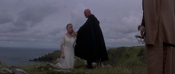 Movie still from “The Three Musketeers” (1993), directed by Stephen Herek – A man and a woman standing on top of a hill; Wide shot, Low angle