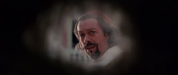 Movie still from “The Three Musketeers” (1993), directed by Stephen Herek – A man with long hair and a beard is looking at the camera; Close Up shot, Over the shoulder angle