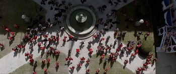 Movie still from “The Three Musketeers” (1993), directed by Stephen Herek – An aerial view of a crowd of people gathered around a fountain; Extreme Wide shot, Overhead angle