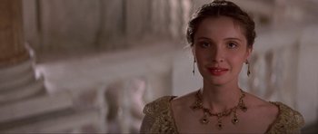 Movie still from “The Three Musketeers” (1993), directed by Stephen Herek – A beautiful young woman wearing a gold dress; Close Up shot, Over the shoulder angle