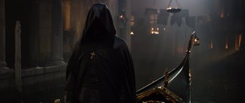 Movie still from “The Three Musketeers” (2011), directed by Paul W.S. Anderson – A person wearing a black robe and a cross on his chest; Wide shot, Low angle