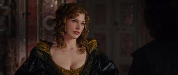 Movie still from “The Three Musketeers” (2011), directed by Paul W.S. Anderson – A beautiful woman with long curly hair and a yellow dress; Close Up shot, Over the shoulder angle