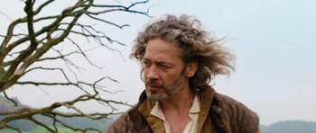 Movie still from “The Three Musketeers” (2011), directed by Paul W.S. Anderson – A man with long hair and a beard is standing in front of a tree; Close Up shot, Low angle