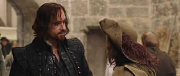 Movie still from “The Three Musketeers” (2011), directed by Paul W.S. Anderson – A man and a woman in medieval garb talking to each other; Medium shot, Over the shoulder angle