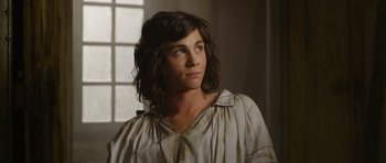 Movie still from “The Three Musketeers” (2011), directed by Paul W.S. Anderson – A woman with long brown hair looking to her left; Close Up shot, Over the shoulder angle